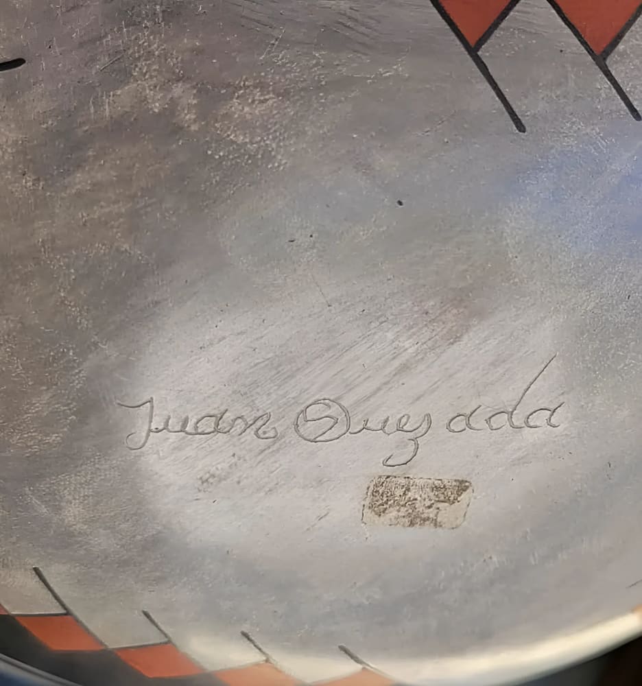 A ceramic vessel with an etched signature.