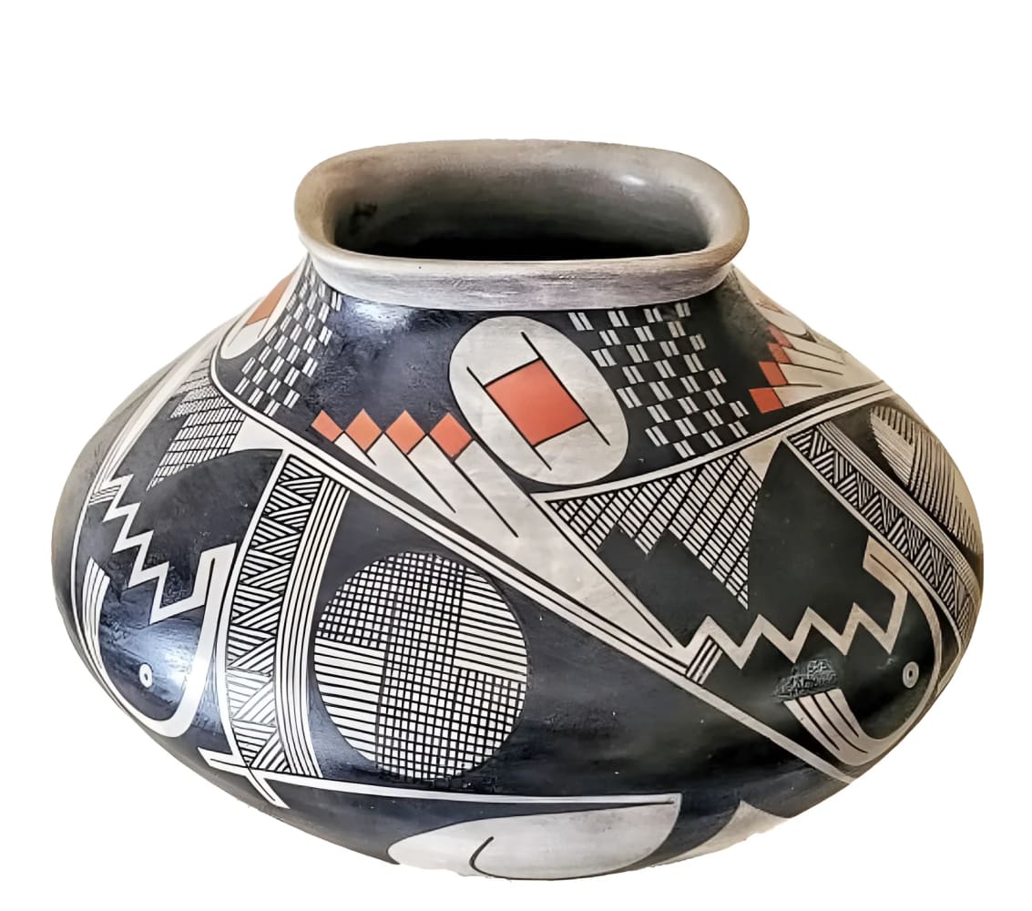 A black pottery jar with geometric designs and red accents.