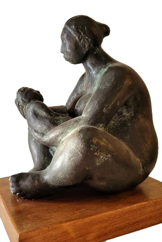 A bronze sculpture of a seated woman holding a child.