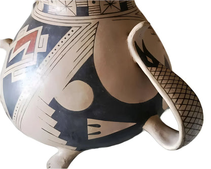 A hand-painted ceramic pot with a handle and tripod base.