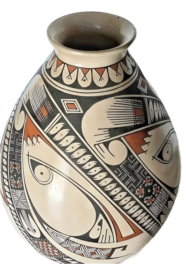 A handcrafted, teardrop-shaped ceramic vase with intricate black, white, and terracotta geometric patterns and stylized eye motifs.
