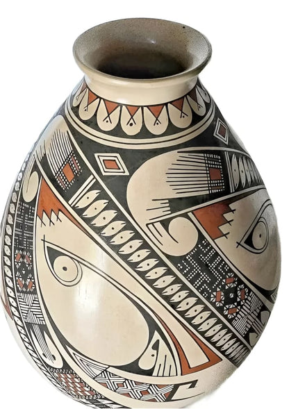 A handcrafted, teardrop-shaped ceramic vase with intricate black, white, and terracotta geometric patterns and stylized eye motifs.