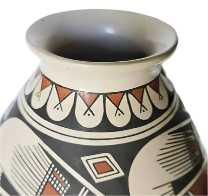 Hand-painted ceramic vase with a flared rim and geometric patterns in black, white, and terracotta.