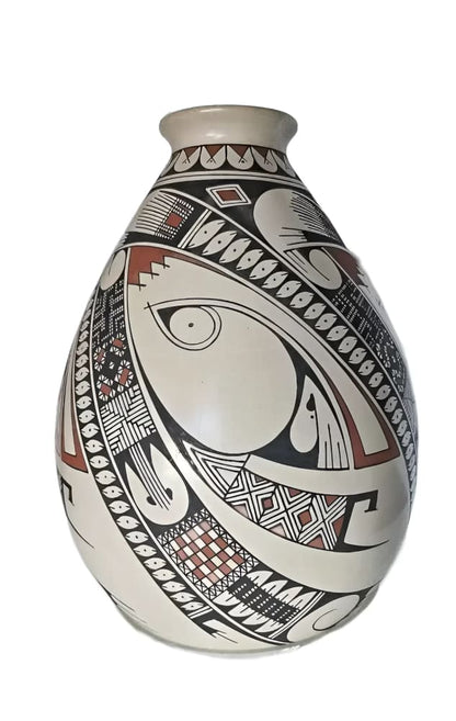 A cream-colored pottery vase with intricate black and reddish-brown geometric patterns.