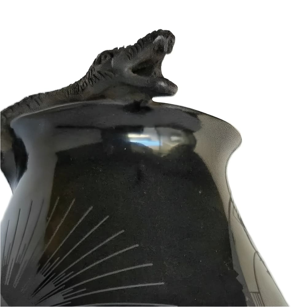 Black ceramic vessel with a snake sculpture and radiating line design.
